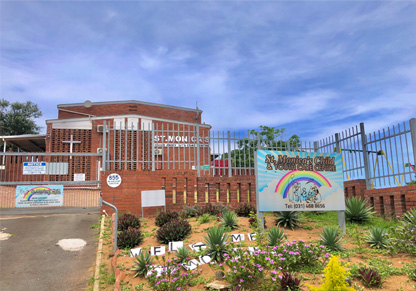The exterior of a children's home featuring the name sign with a rainbow on it. 