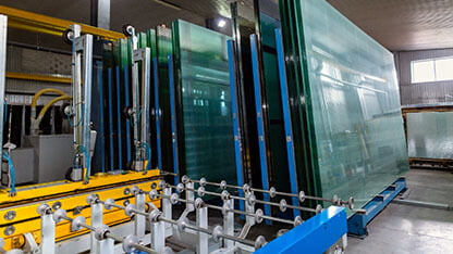 Factory for the production of double-glazed windows made of sheet glass. Sheet glass in pallets near the sheet glass cutting line. 